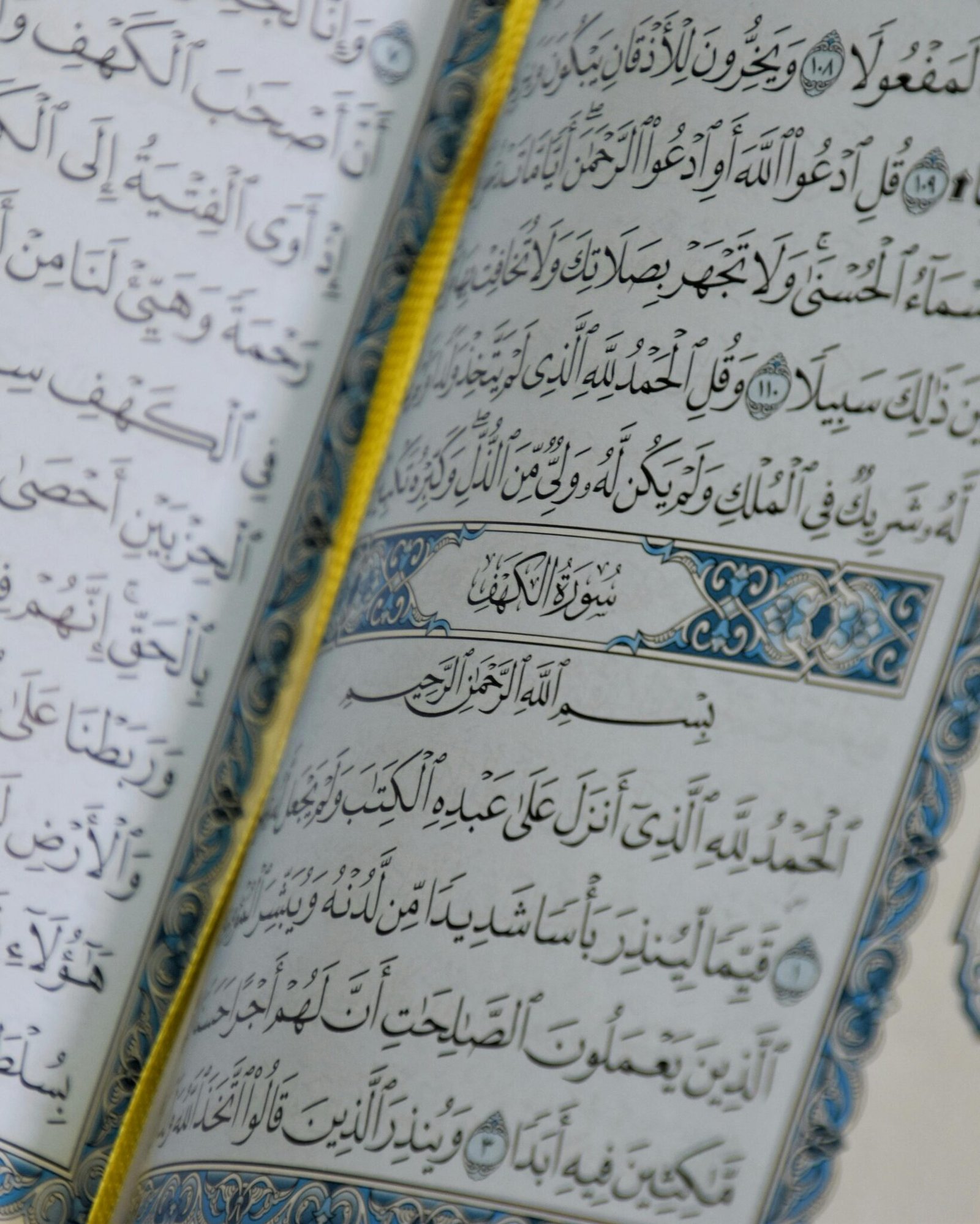 Close-up of an open Quran showing Arabic script and intricate designs, symbolizing Islamic faith.
